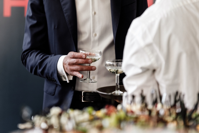 men in suits holding cocktail glasses